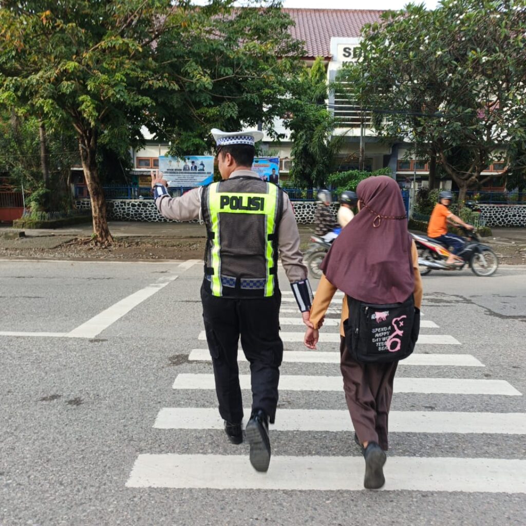Sat Lantas Polres Bima Kota Bantu Seberangkan Pejalan Kaki dan Anak Sekolah, Ciptakan Kamseltibcarlantas yang Lancar