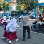 Bantu Pelajar Menyeberang, Personel Polsek Rastim Hadir dalam Pelayanan Rawan Pagi
