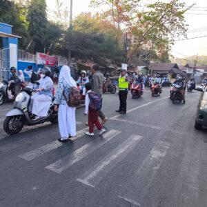 Berikan Rasa Aman, Sat Lantas Polres Bima Kota Bantu Pelajar Menyeberang di Jam Sibuk Pagi